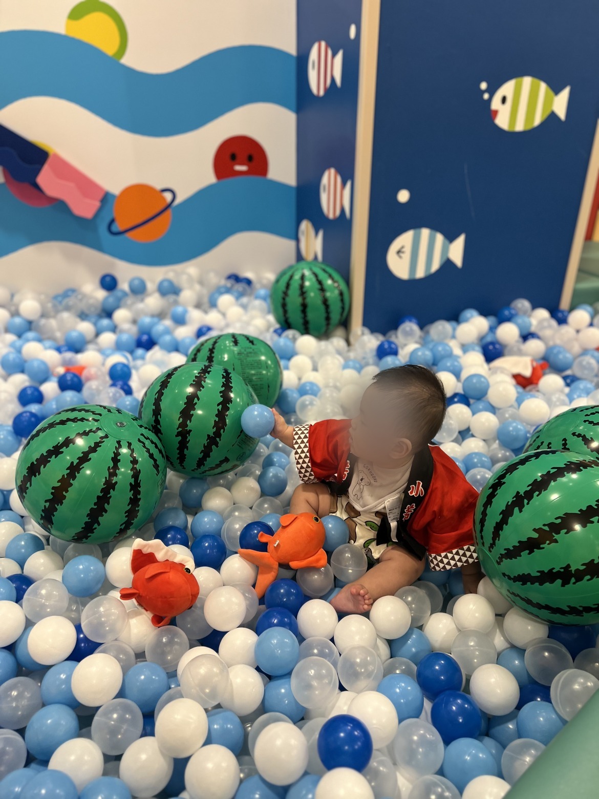 すいかのボールプールで遊ぶ甚平姿の子ども