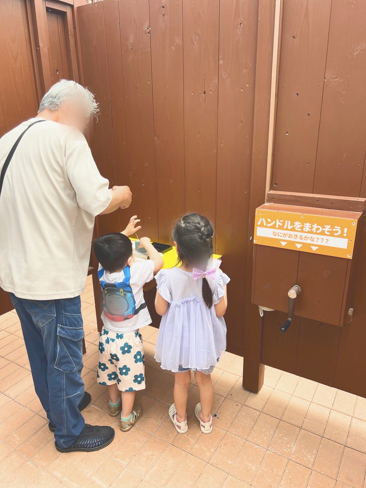 「ハンドルをまわそう!」の展示に集まる祖父と子どもたち