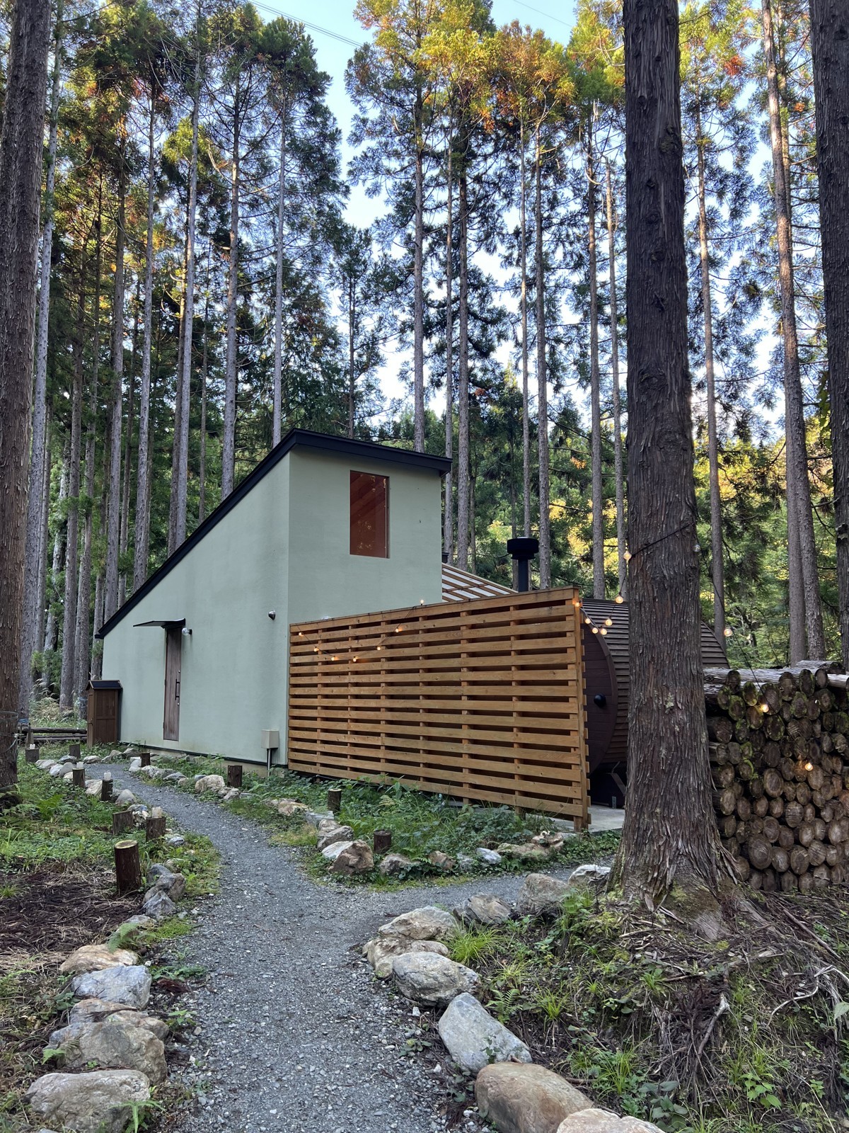 森の中に建つSOILの棟。手前に白いタープ