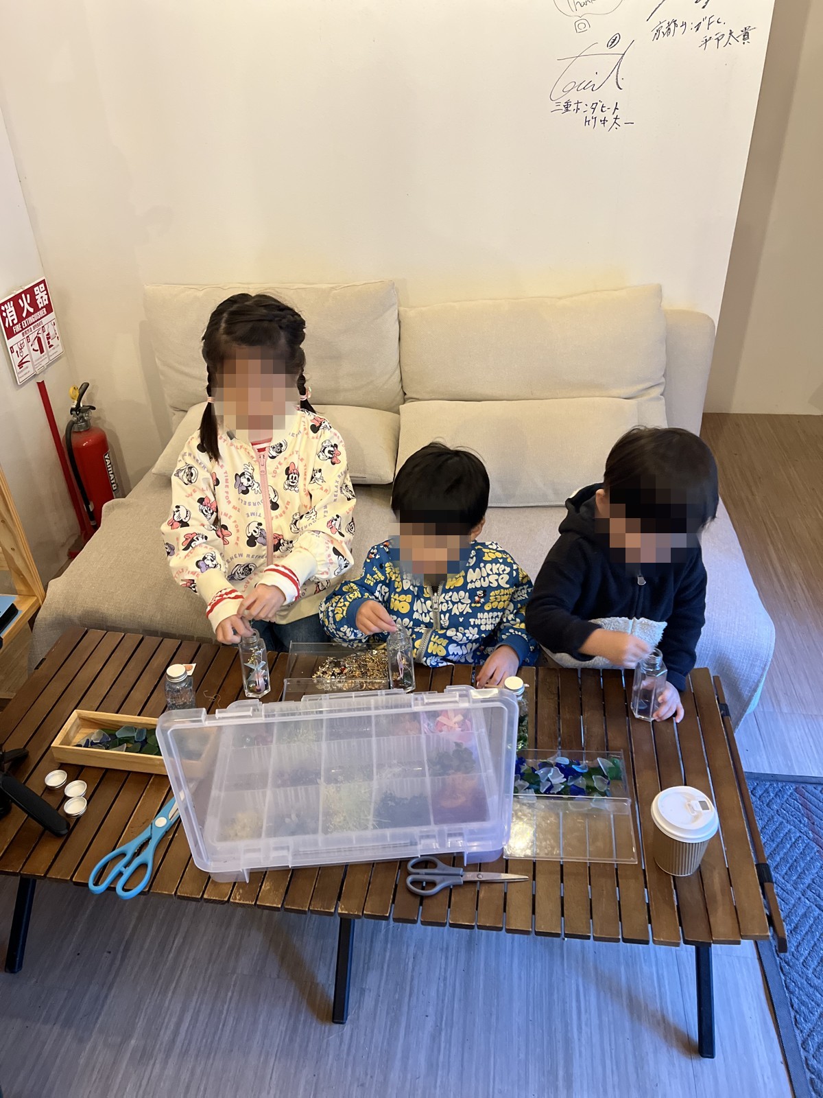 室内のテーブルで工作をする子どもたち