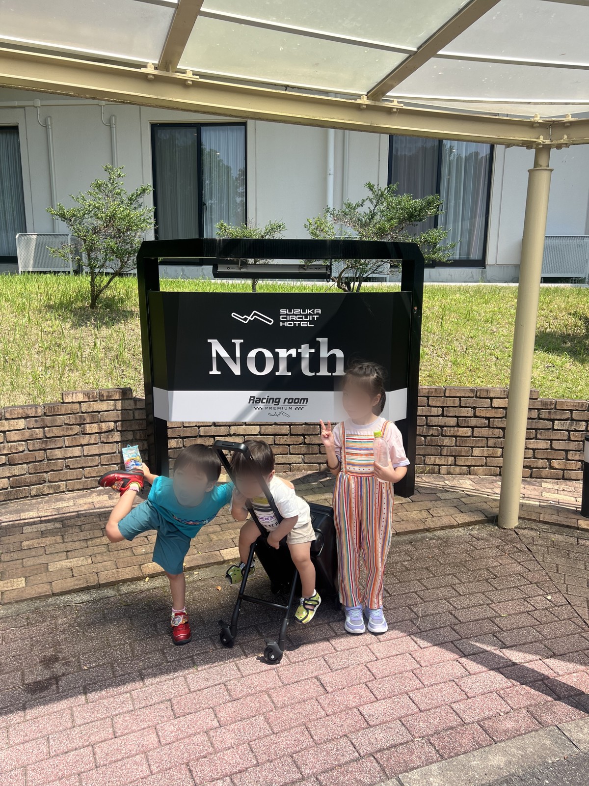 「SUZUKA CIRCUIT HOTEL North」の看板の前に立つ子どもたち