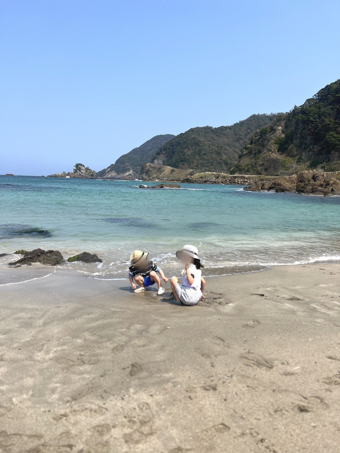遠浅の波打ち際で遊ぶ子どもたち