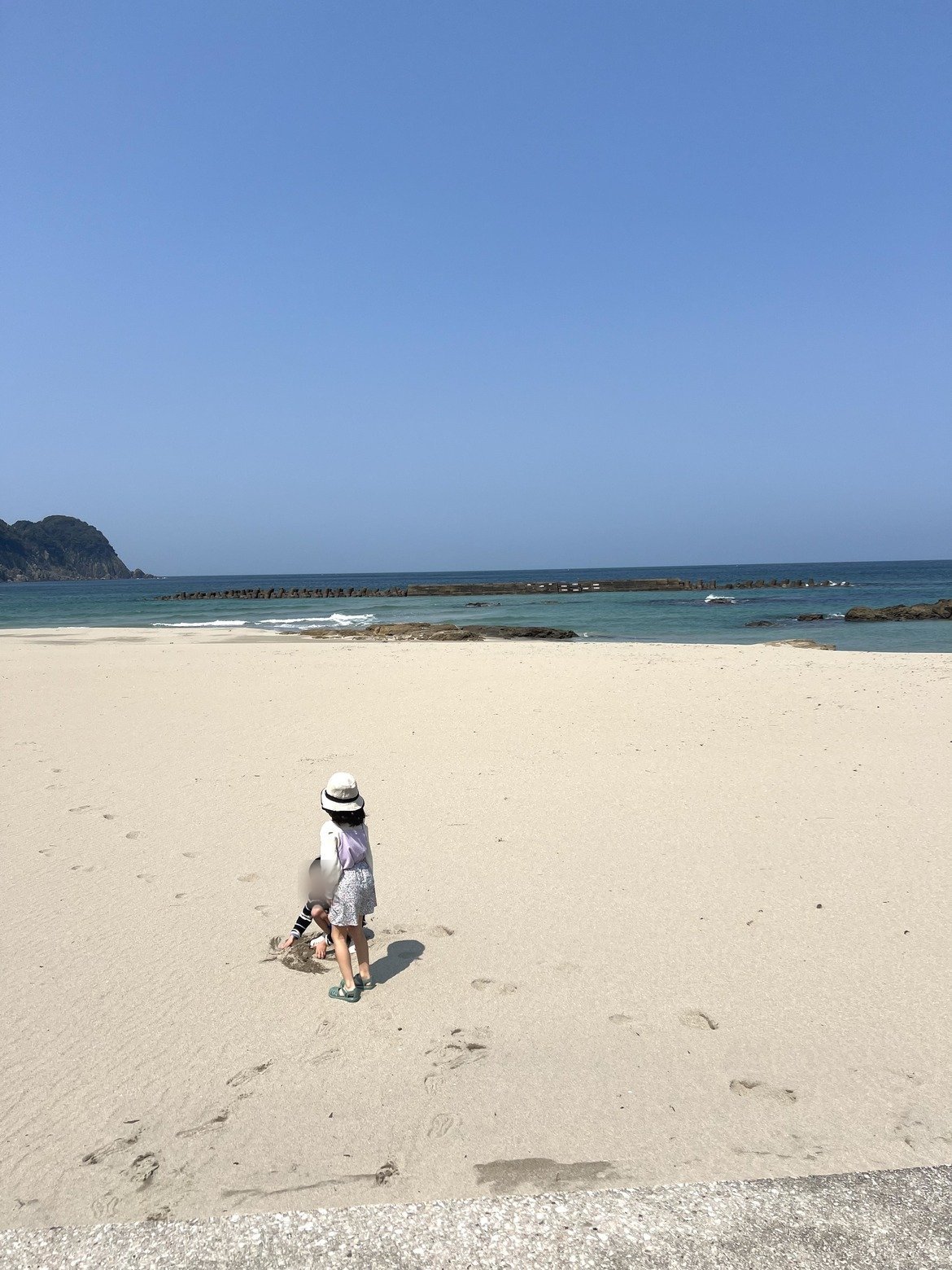 真っ白な砂浜を歩く子ども