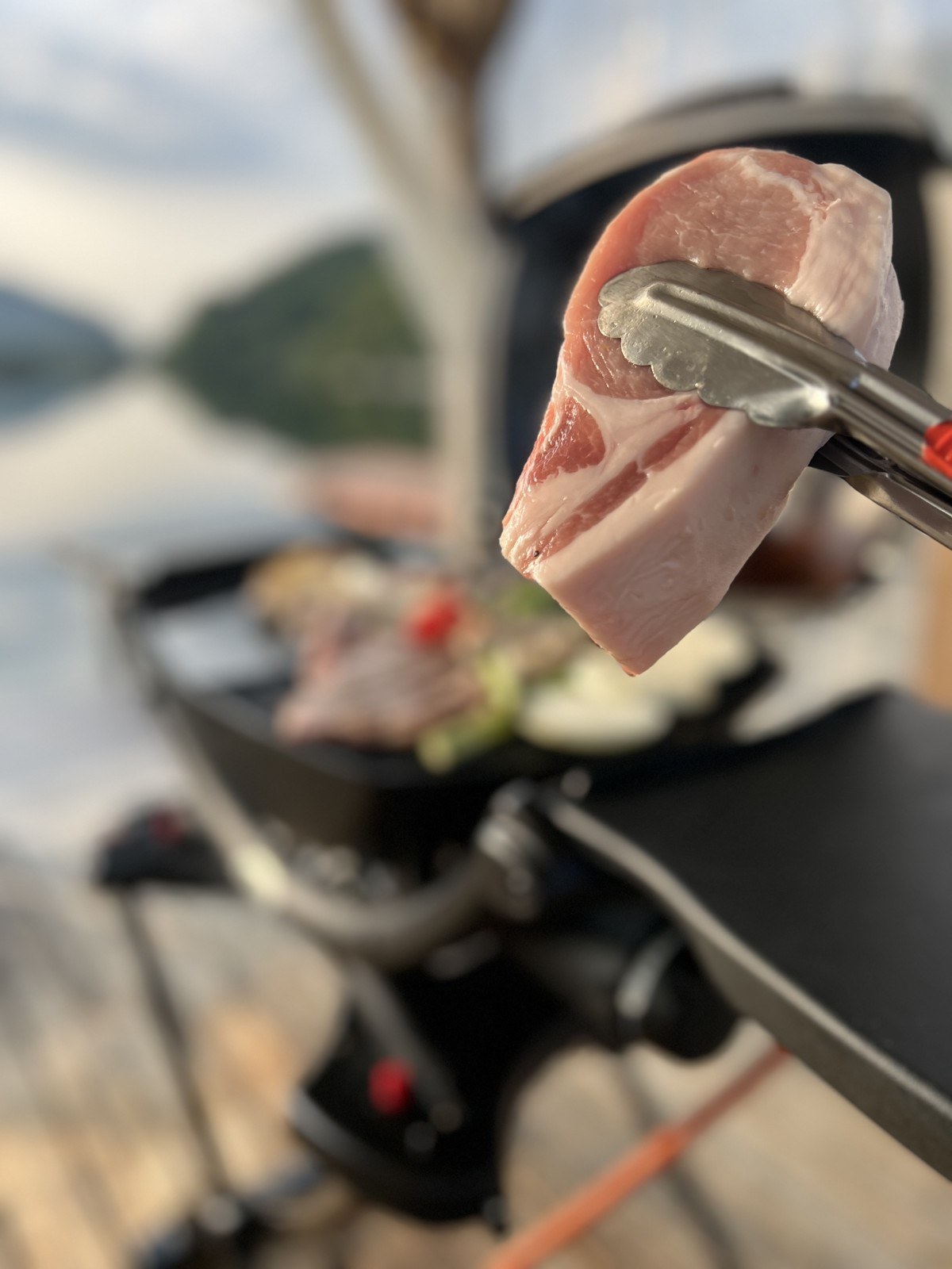 グリルで肉をトングでつかむ