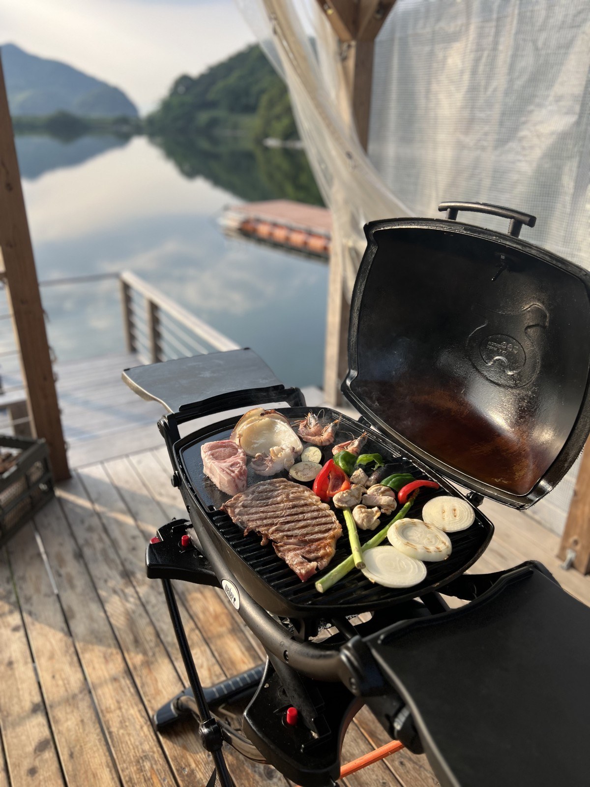デッキのグリルで焼く肉と野菜。奥は海