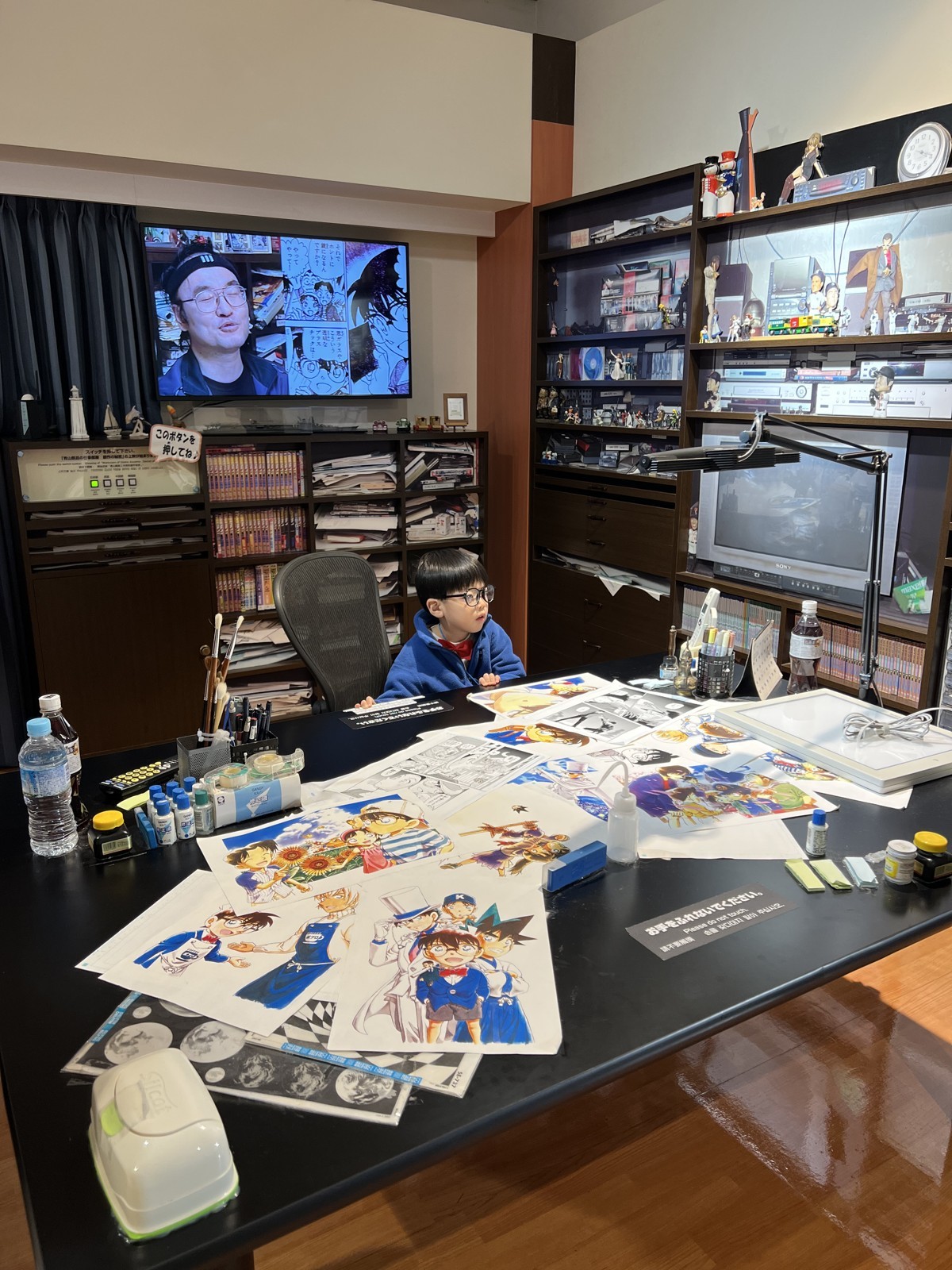 青山剛昌さんの仕事場を再現した展示。机に原稿が広がっている