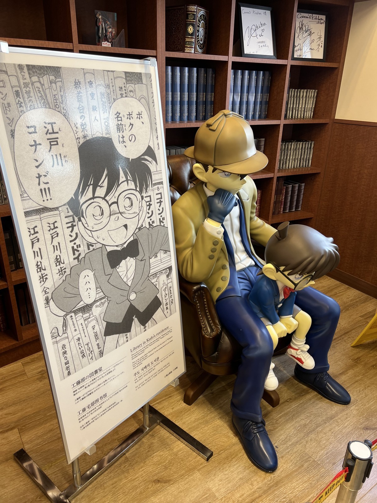 本棚の前のベンチに座る江戸川コナンの像