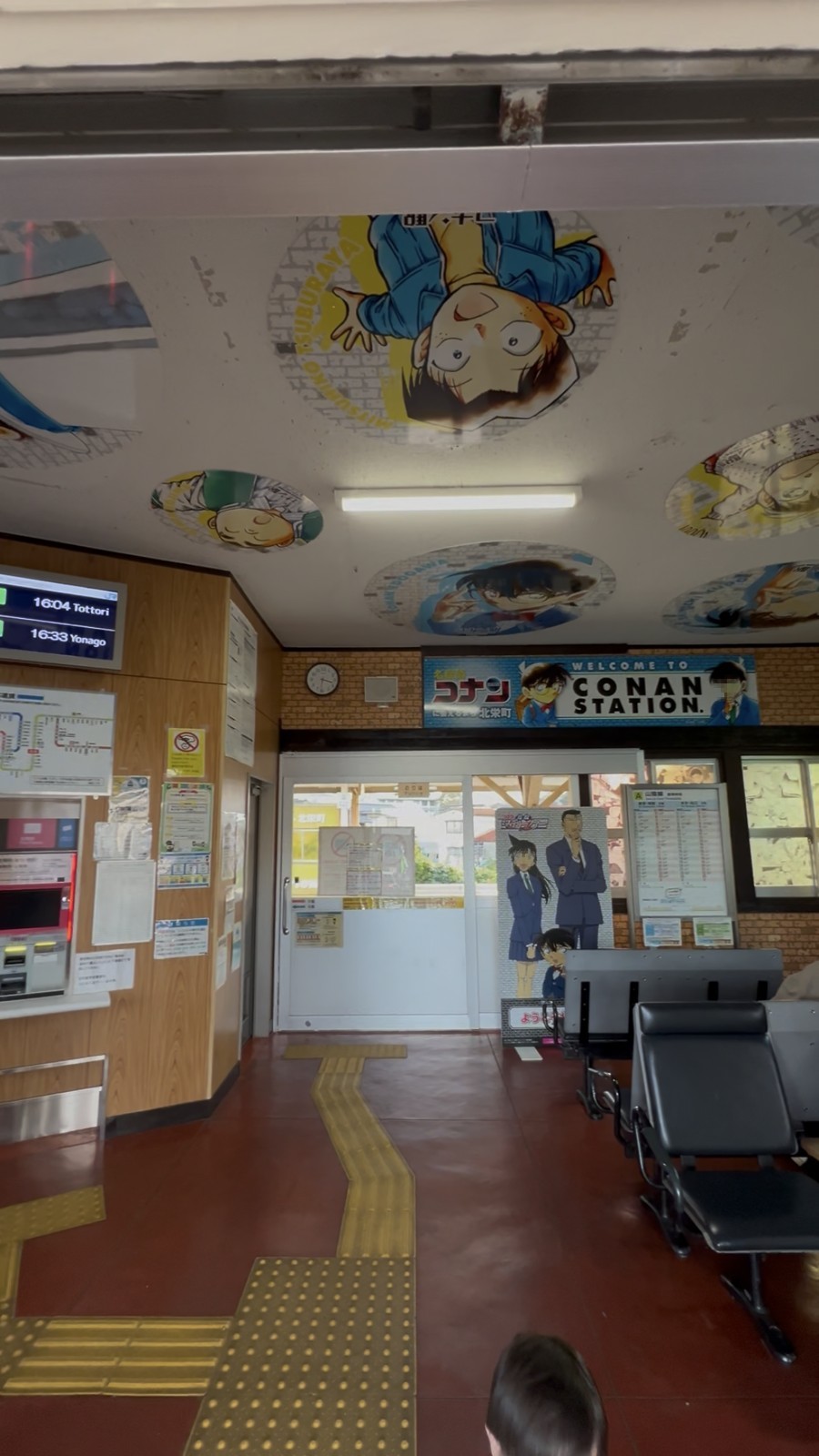 駅舎の中。天井にコナンのキャラクターが描かれ、CONAN STATIONの看板が出ている