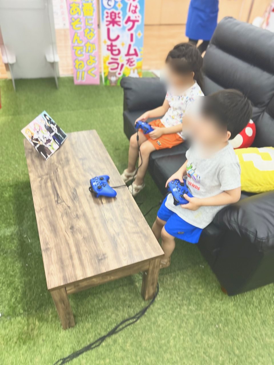 ソファに座ってゲームをする子どもたち