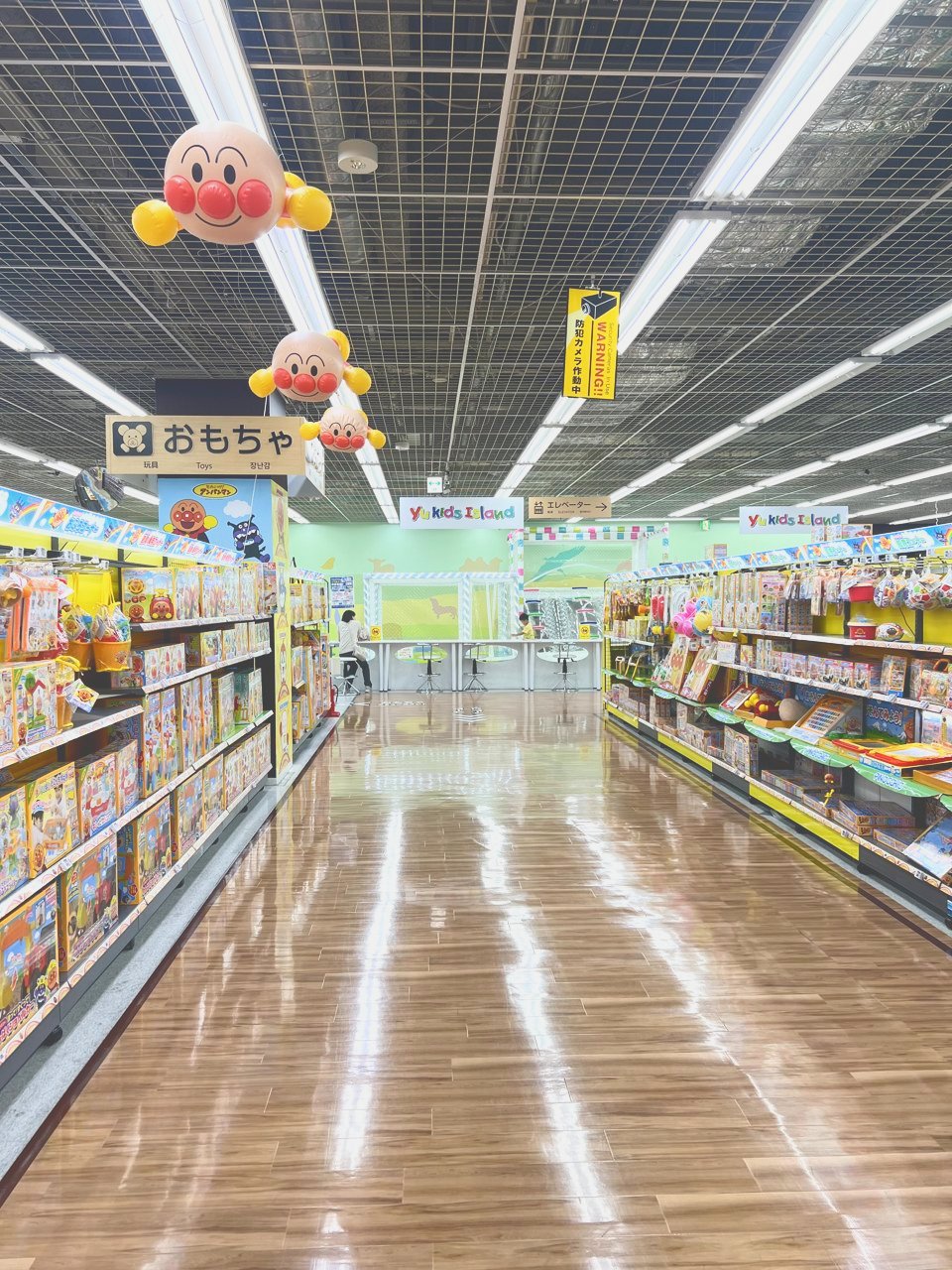 おもちゃ売り場の通路の先に、遊び場の看板が見える